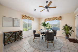 Dining space featuring light tile patterned flooring and a ceiling fan