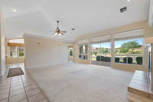 Unfurnished living room with light colored carpet, lofted ceiling, ceiling fan, light tile patterned floors, and recessed lighting