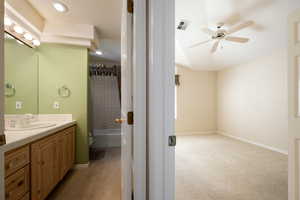 Bathroom featuring vanity, shower / bath combo, and ceiling fan