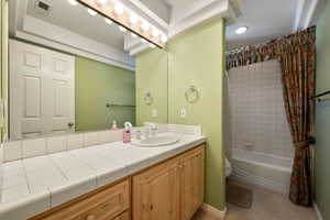 Full bath with shower / bath combo with shower curtain and vanity