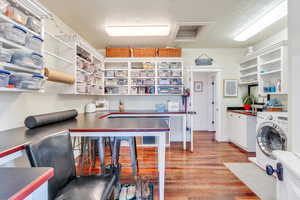 Kitchen with washer / clothes dryer, white cabinets, a textured ceiling, light wood-type flooring, and open shelves