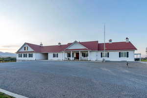 View of front of home featuring a chimney, a metal roof, a porch, and a standing seam roof