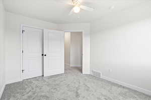 Unfurnished bedroom with light carpet and ceiling fan