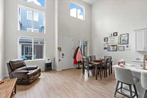 Dining area with a towering ceiling and light wood-style floors