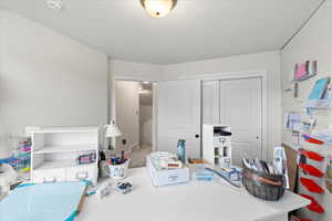Bedroom with a closet, a textured ceiling, and carpet floors