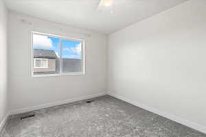 Carpeted empty room with baseboards and a ceiling fan