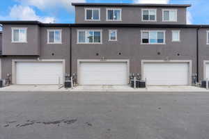 Rear view of property with stucco siding and an attached garage