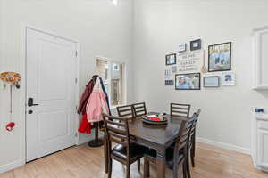 Dining space with light wood finished floors and a high ceiling