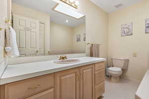 Bathroom featuring light tile patterned floors, a skylight, vanity, and recessed lighting