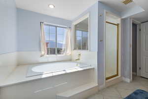 Full bath with a stall shower, a bath, a mountain view, and light tile patterned flooring