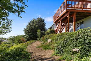 View of yard with a wooden deck and stairway