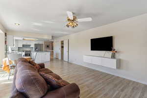 Living room featuring light wood finished floors and a ceiling fan