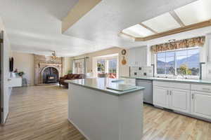 Kitchen featuring a kitchen island, light wood-type flooring, a mountain view, and open floor plan