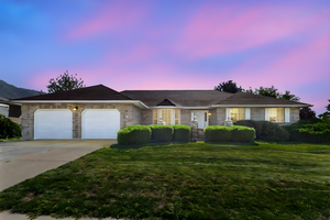 Ranch-style home featuring a garage, driveway, a front lawn, and brick siding