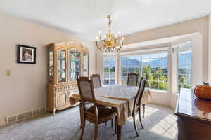 Formal Dining space with a mountain view, carpet floors, and a chandelier