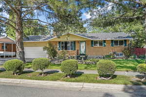 Single story home with brick siding, an attached garage, and roof with shingles