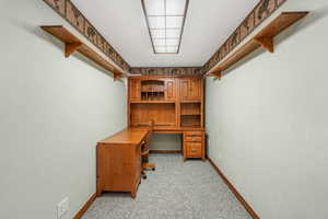 Office space with light colored carpet and baseboards
