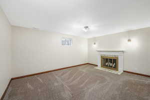 Unfurnished living room featuring carpet and a fireplace
