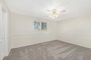 Carpeted empty room with baseboards and ceiling fan