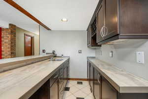 Kitchen with dark brown cabinets, light tile patterned flooring, and recessed lighting
