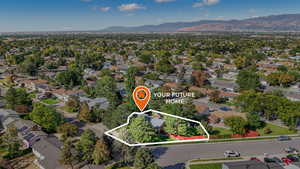 Aerial view of residential area with a mountainous background and property parcel outlined