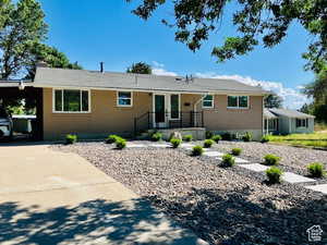 Ranch-style house featuring brick siding, a chimney, concrete driveway, and an attached carport