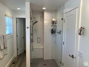 Full bath with a stall shower, dark wood finished floors, and recessed lighting