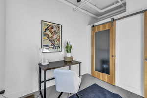 Second bedroom featuring concrete floors and a barn door
