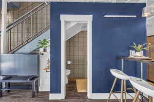 Bathroom featuring wood finished floors and tile walls