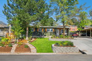 View of front of property with a front lawn, concrete driveway, and brick siding