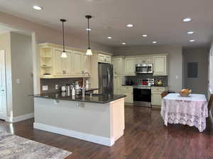 Kitchen featuring cream cabinetry, backsplash, stainless steel appliances, pendant lighting, and recessed lighting