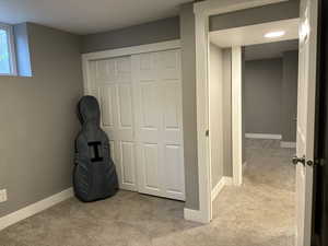 Unfurnished room featuring light carpet and baseboards