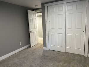 Unfurnished bedroom with light carpet and a closet