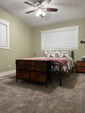 Bedroom featuring dark colored carpet, ceiling fan, and a textured ceiling