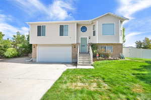 Bi-level home featuring brick siding, driveway, and an attached garage