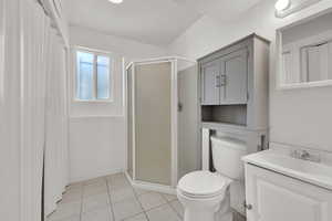 Bathroom featuring a shower stall, vanity, and light tile patterned floors