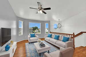 Living area featuring wood finished floors, a chandelier, and ceiling fan