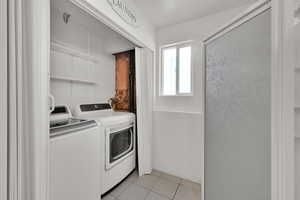 Washroom featuring light tile patterned floors and independent washer and dryer
