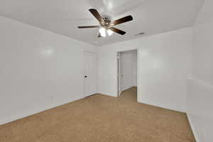 Carpeted spare room with baseboards and ceiling fan