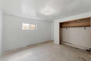Unfurnished bedroom featuring a closet and concrete floors