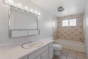 Bathroom with bathtub / shower combination, vanity, and light tile patterned floors