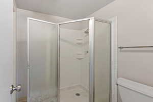 Bathroom featuring a stall shower and toilet