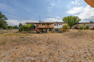 Back of house featuring stairs and a wooden deck