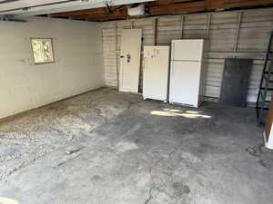 Garage featuring freestanding refrigerator and a garage door opener