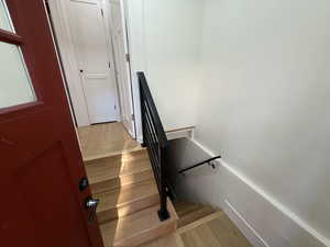 Stairway featuring wood finished floors