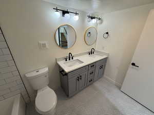 Full bath featuring double vanity and light tile patterned floors