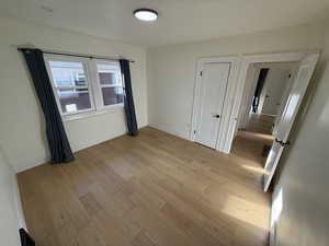 Unfurnished bedroom featuring light wood finished floors and baseboards