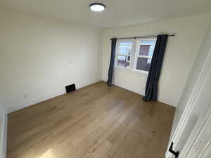 Empty room with light wood-style floors and baseboards