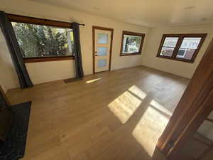 Empty room with healthy amount of natural light and hardwood / wood-style floors