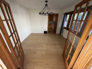 Unfurnished dining area with light wood finished floors and a chandelier